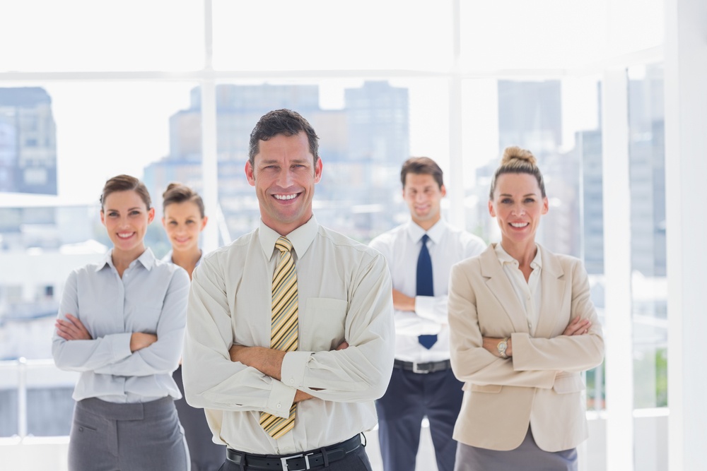 Smiling handsome businessman with his team in a modern office